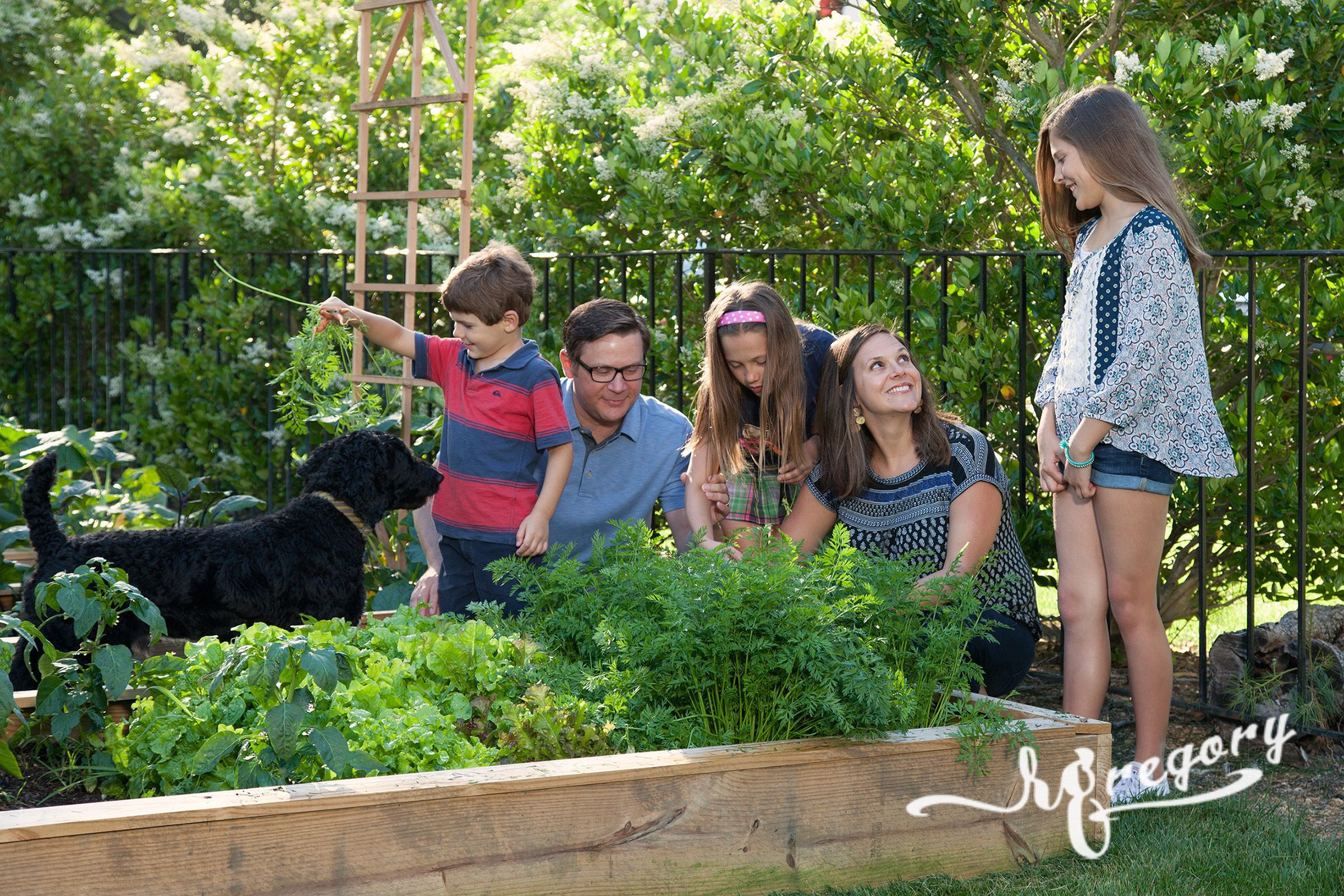 family gardening candid photo with children and pet dog